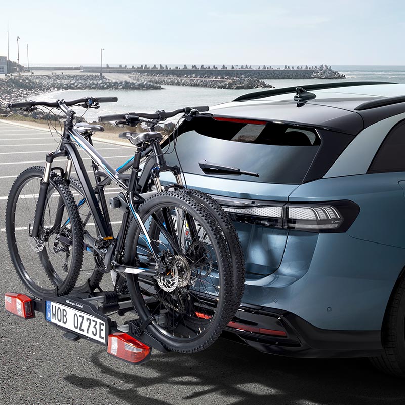 Heckansicht eines VW Kombis mit montiertem Fahrradträger und zwei Fahrrädern.